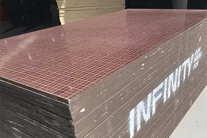 Pilha de compensado plastificado 2 processos (18 mm) com filme marrom para formas de concreto, com marca “Infinity” na lateral da chapa.