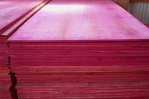 Pilha de chapas de madeirite resinado fenólico (cor rosa) empilhadas, mostrando as bordas e a superfície do painel.