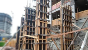 Madeiras para formas de concreto montadas em pilares de edifício em construção usando compensado plastificado.