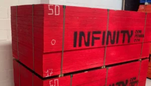 Palete de Madeirite Fenólico pintado de vermelho com a marca Infinity Compensados estampado na lateral, pronto para entrega em obra.